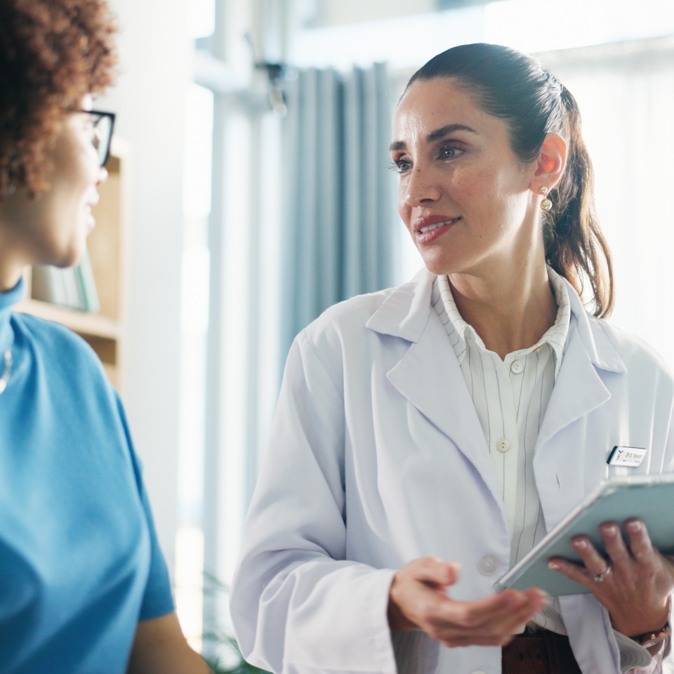 Tablet, checkup and woman with doctor in hospital for healthcare records with treatment plan. Digital technology, consultation and medical worker with patient for research on diagnosis in clinic