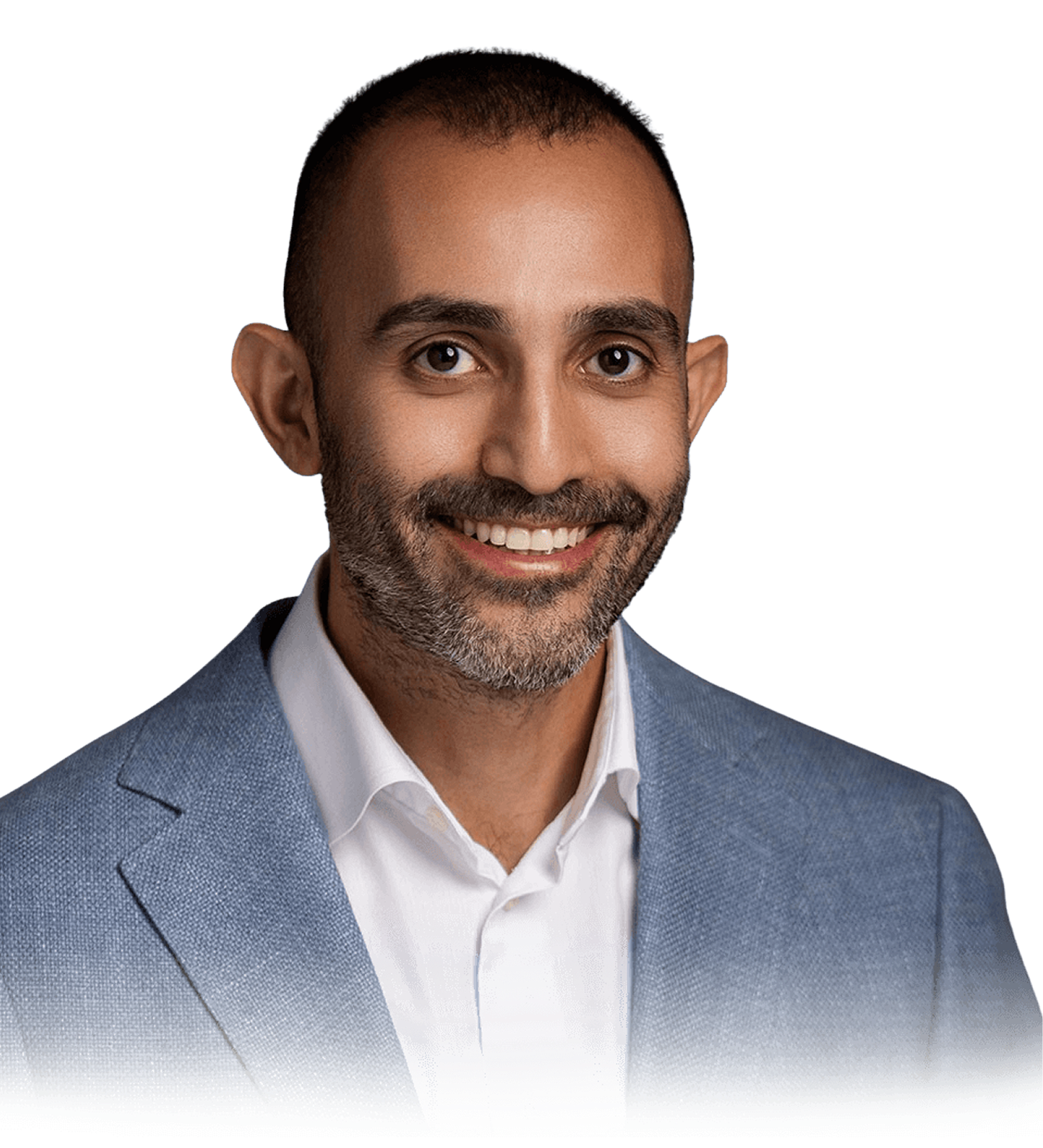 A man with short hair and a trimmed beard, wearing a light blue blazer and white shirt, smiles at the camera against a plain background.