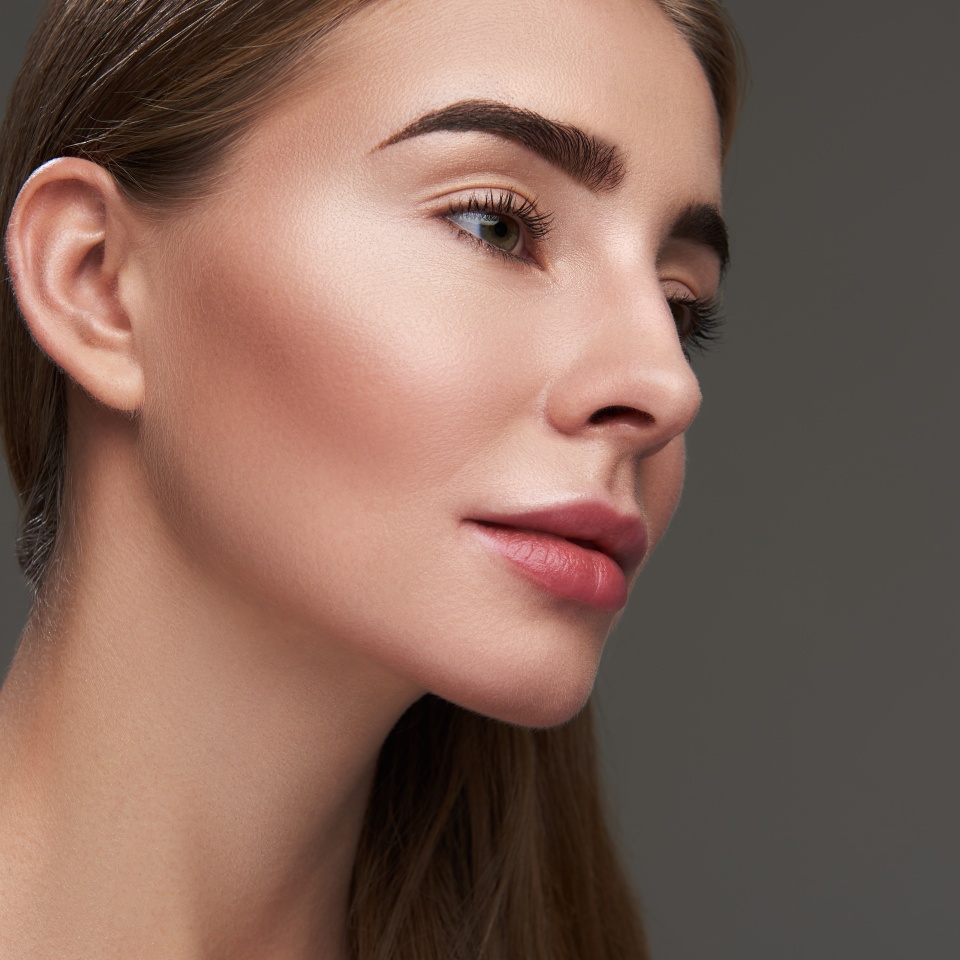 Natural makeup. Close up portrait of beautiful woman with perfect skin looking away with slight smile