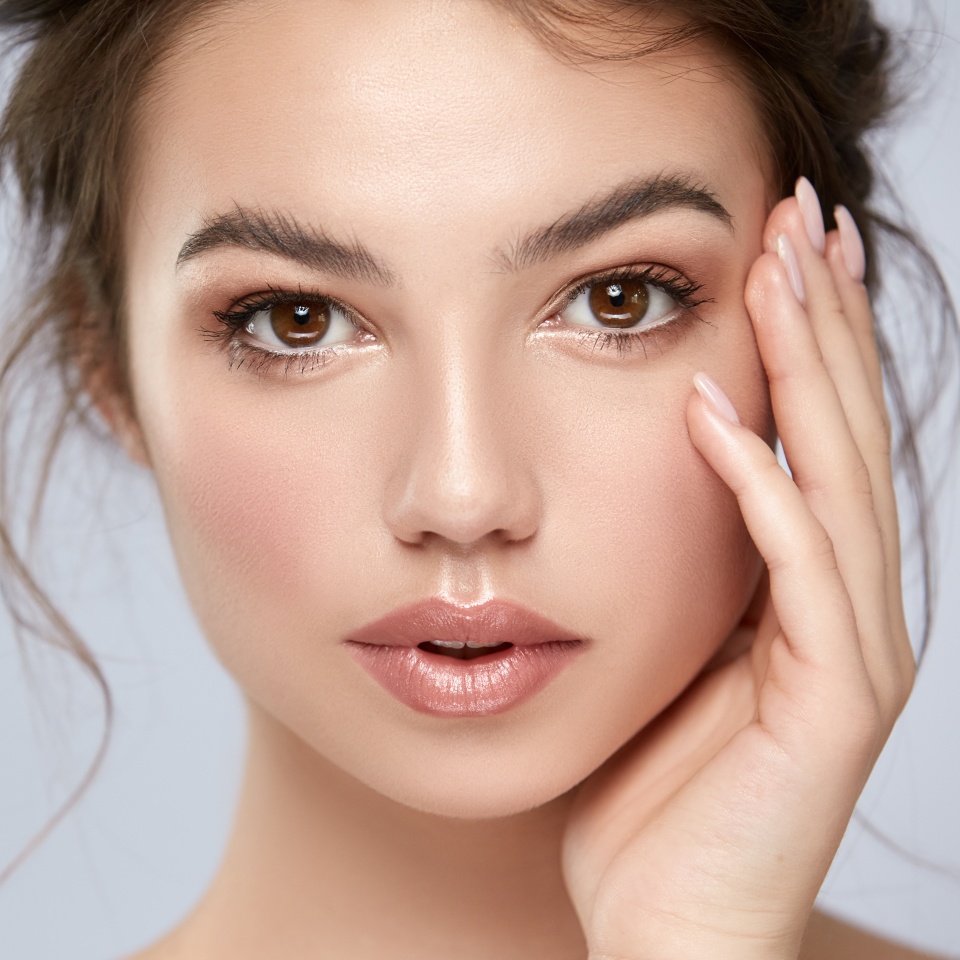 close-up portrait of beautiful girl with big eyes and perfect skin looking to camera, copy space, facial care concept