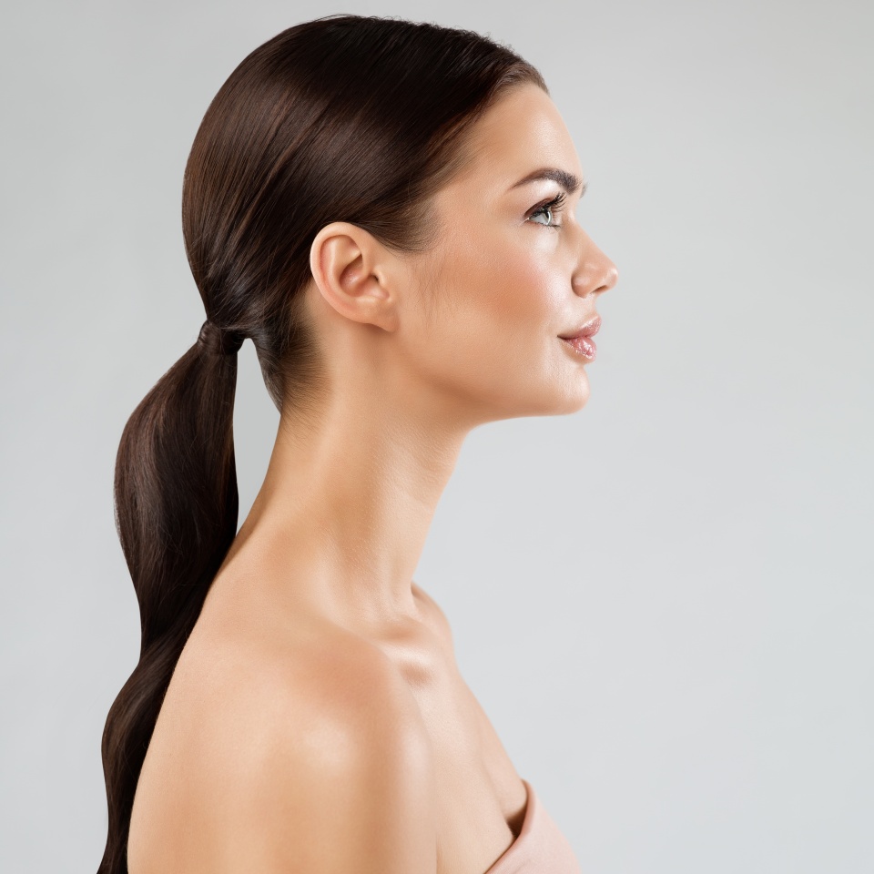 Beauty Model Perfect Face Profile. Brunette Woman with Healthy Smooth Facial Skin and Hair over White. Beautiful Girl Side view Portrait with Full Lips and Natural Make up. Female Plastic Surgery