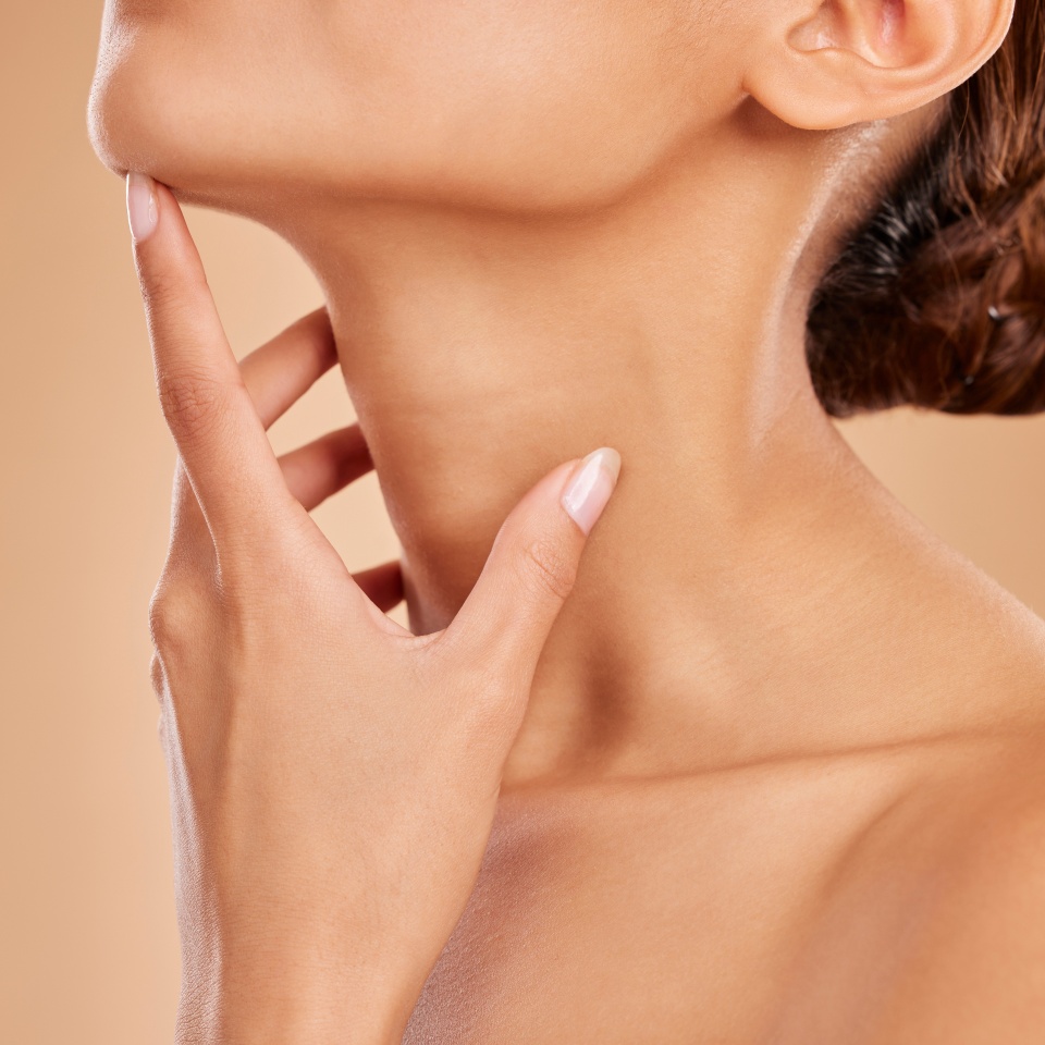 Skincare, beauty and neck of a woman with a glow isolated on a brown background in a studio. Wellness, health and a girl feeling and touching skin for satisfaction, grooming and care for anti aging